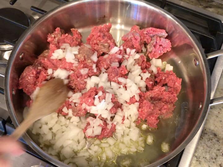 Cooking ground beef and onions in a skillet.