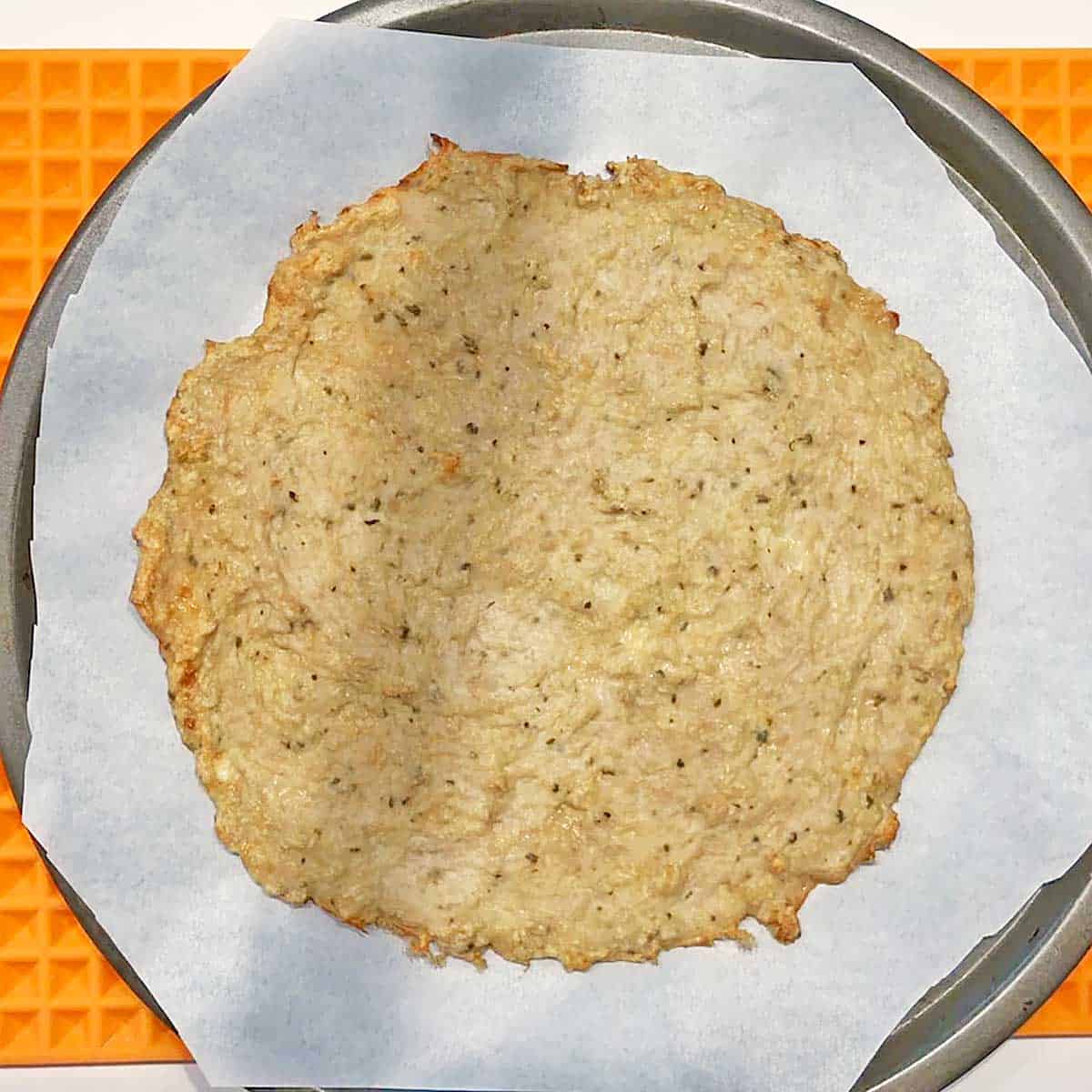 Baked chicken crust is ready for toppings. 