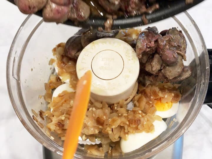 Adding the cooked livers to the food processor.