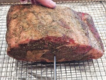 Inserting a thermometer into the roast.