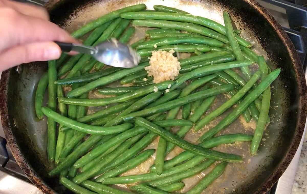 Adding garlic to the skillet.