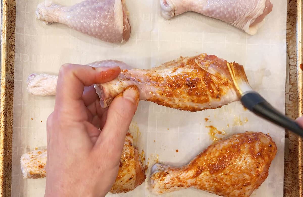 Coating the drumsticks with seasoning mix.