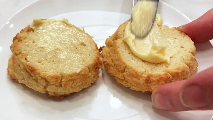 Topping the biscuits with butter.