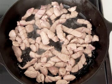 Cooked pieces of pork in a skillet.