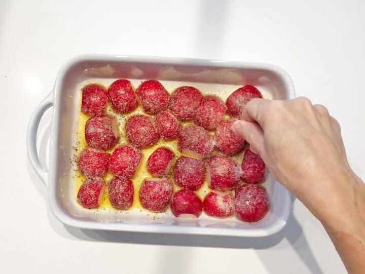 Seasoning the radishes in the pan.