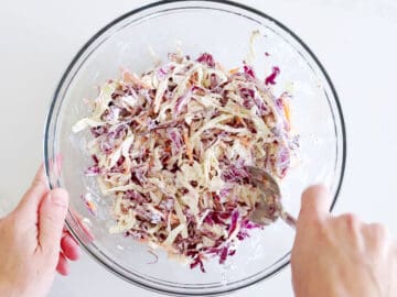 Mixing the cabbage and dressing for coleslaw.