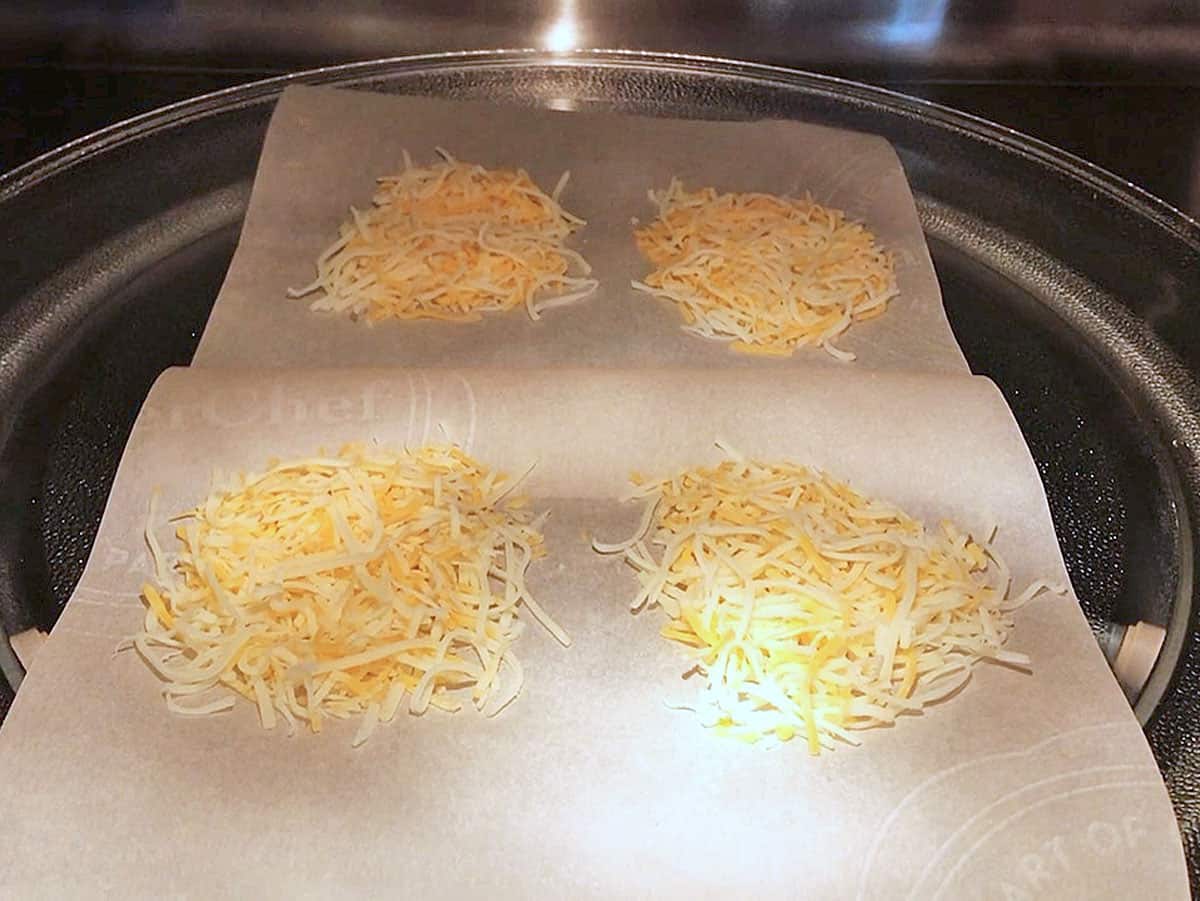 Placing four mounds of cheese in the microwave.