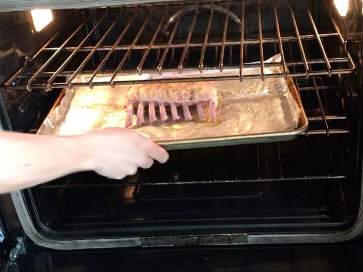 Placing the lamb in the oven.