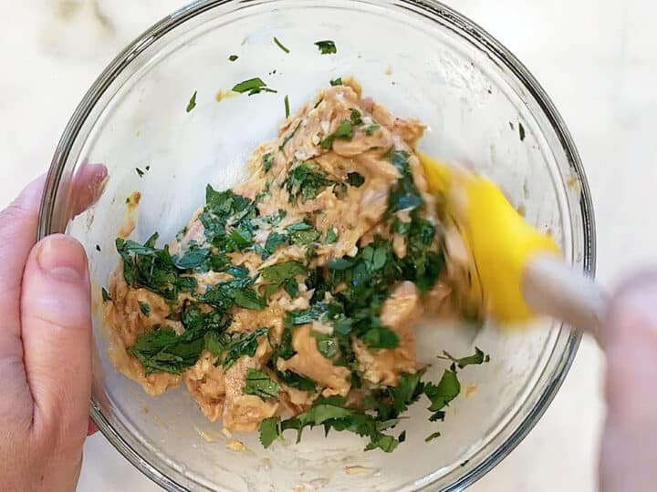 Mixing tuna cakes ingredients.