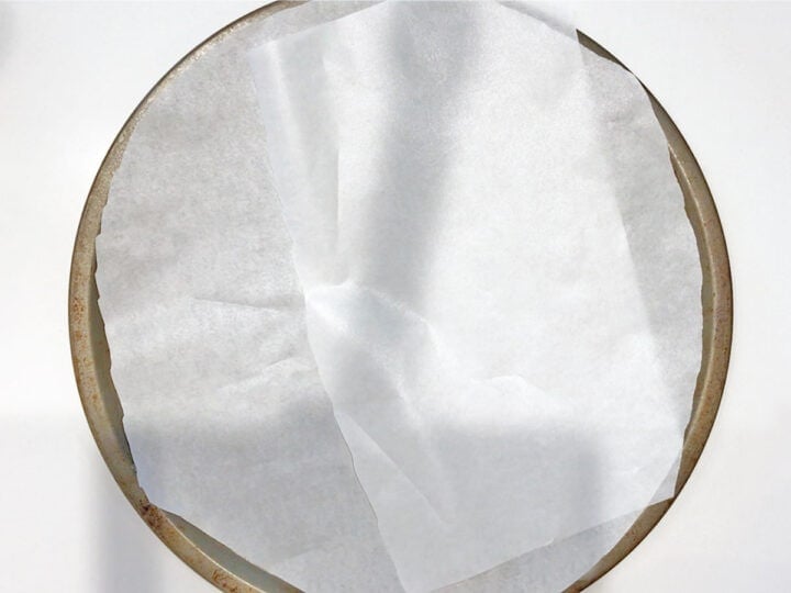 Pizza pan lined with parchment paper.