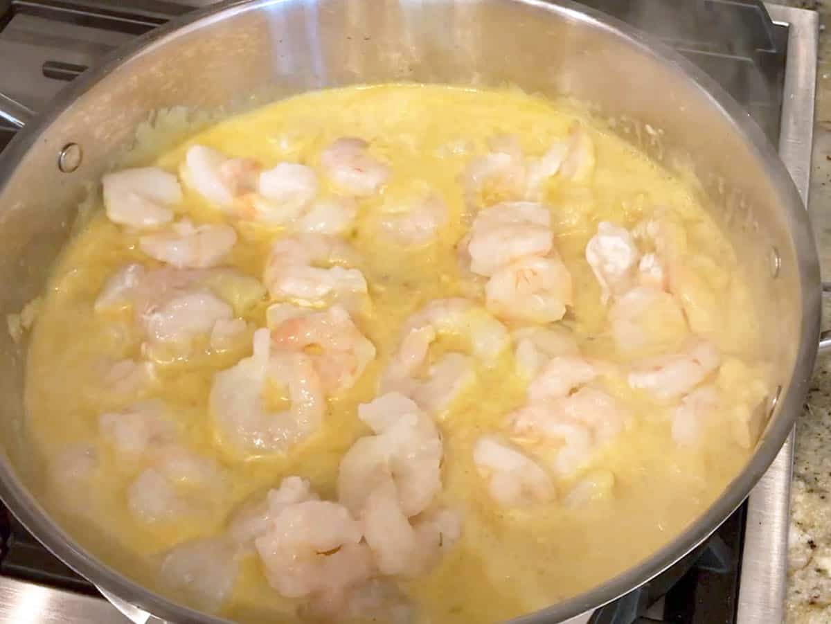 Adding shrimp to the coconut milk broth.
