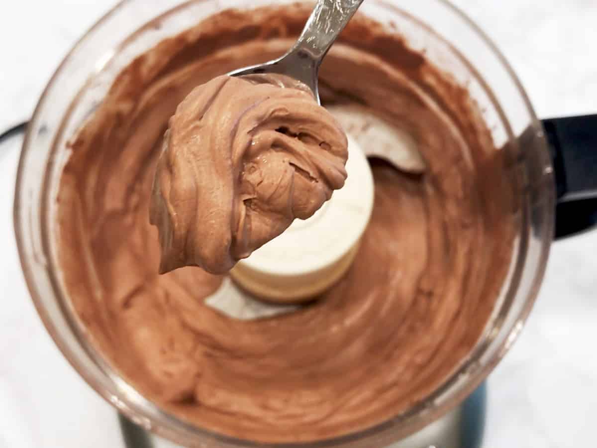 Spooning the mousse to show its desired consistency.