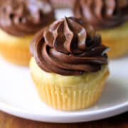 Three vanilla keto cupcakes are served on a white plate.