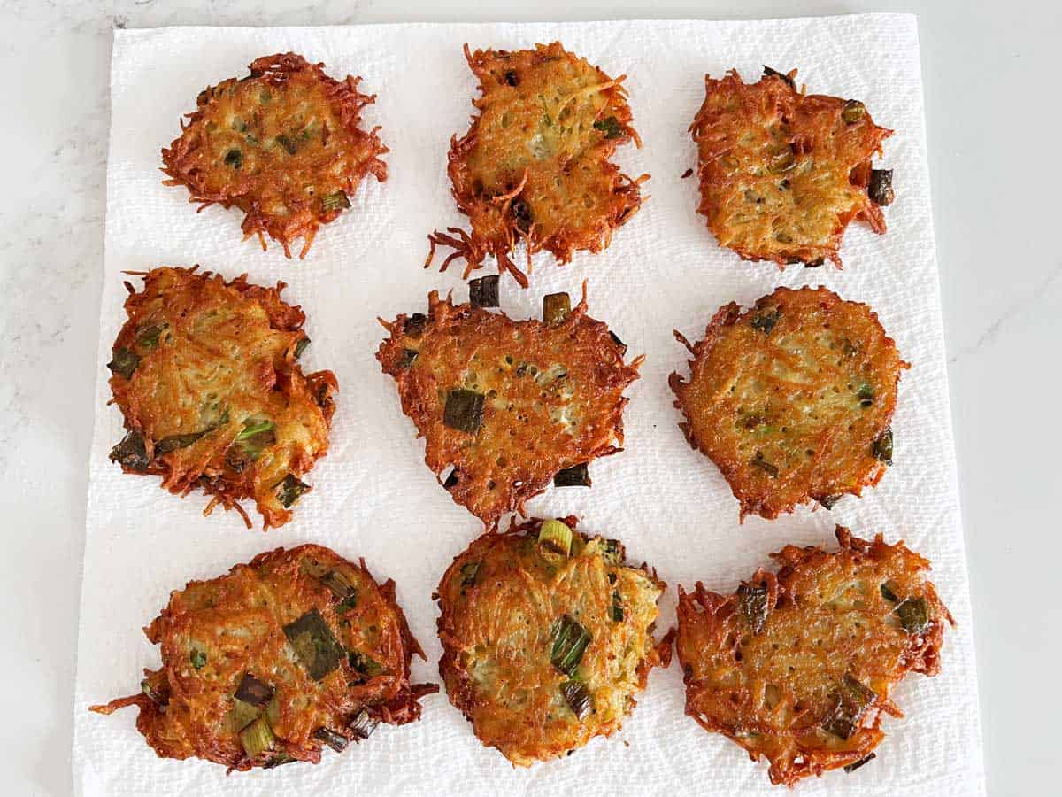 Placing the latkes on paper towels to absorb oil.