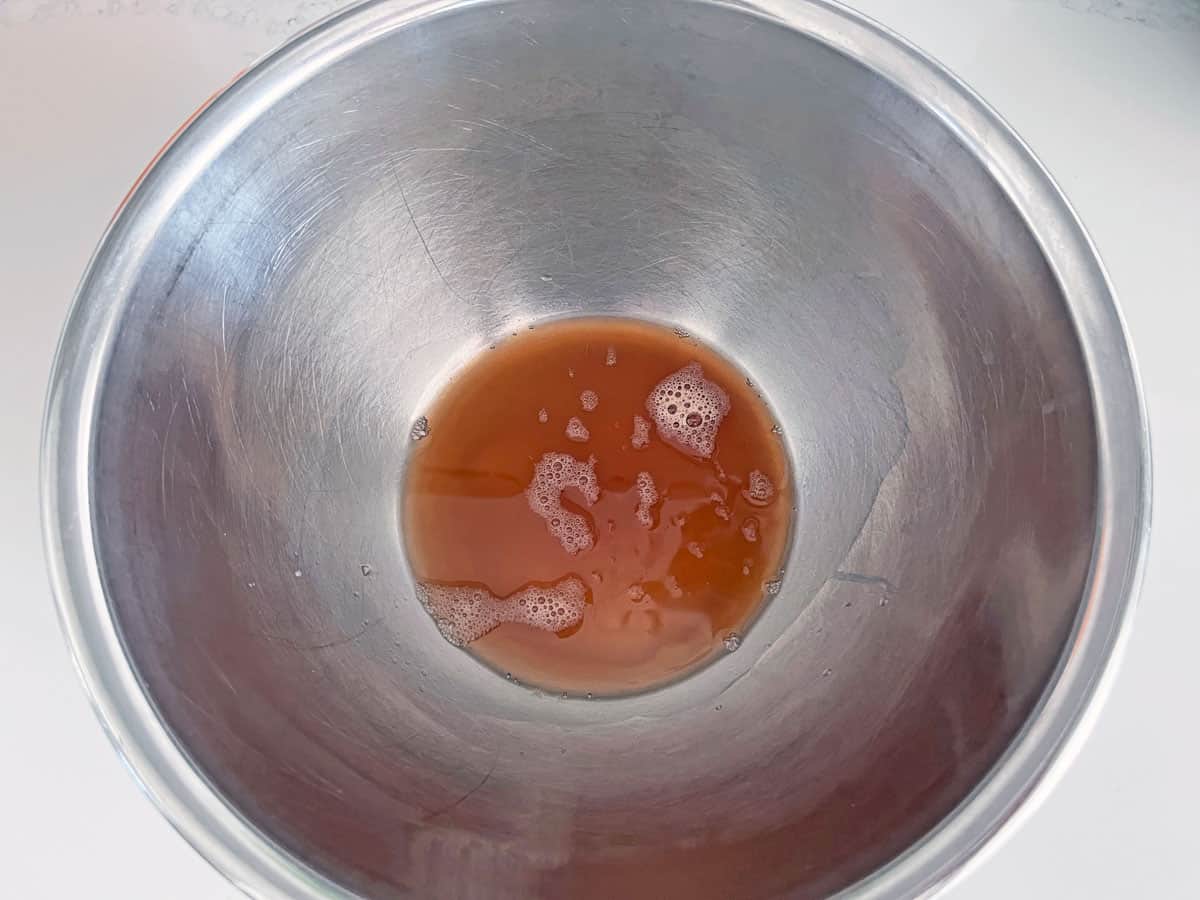 The water left in the bowl after draining the shredded potatoes.