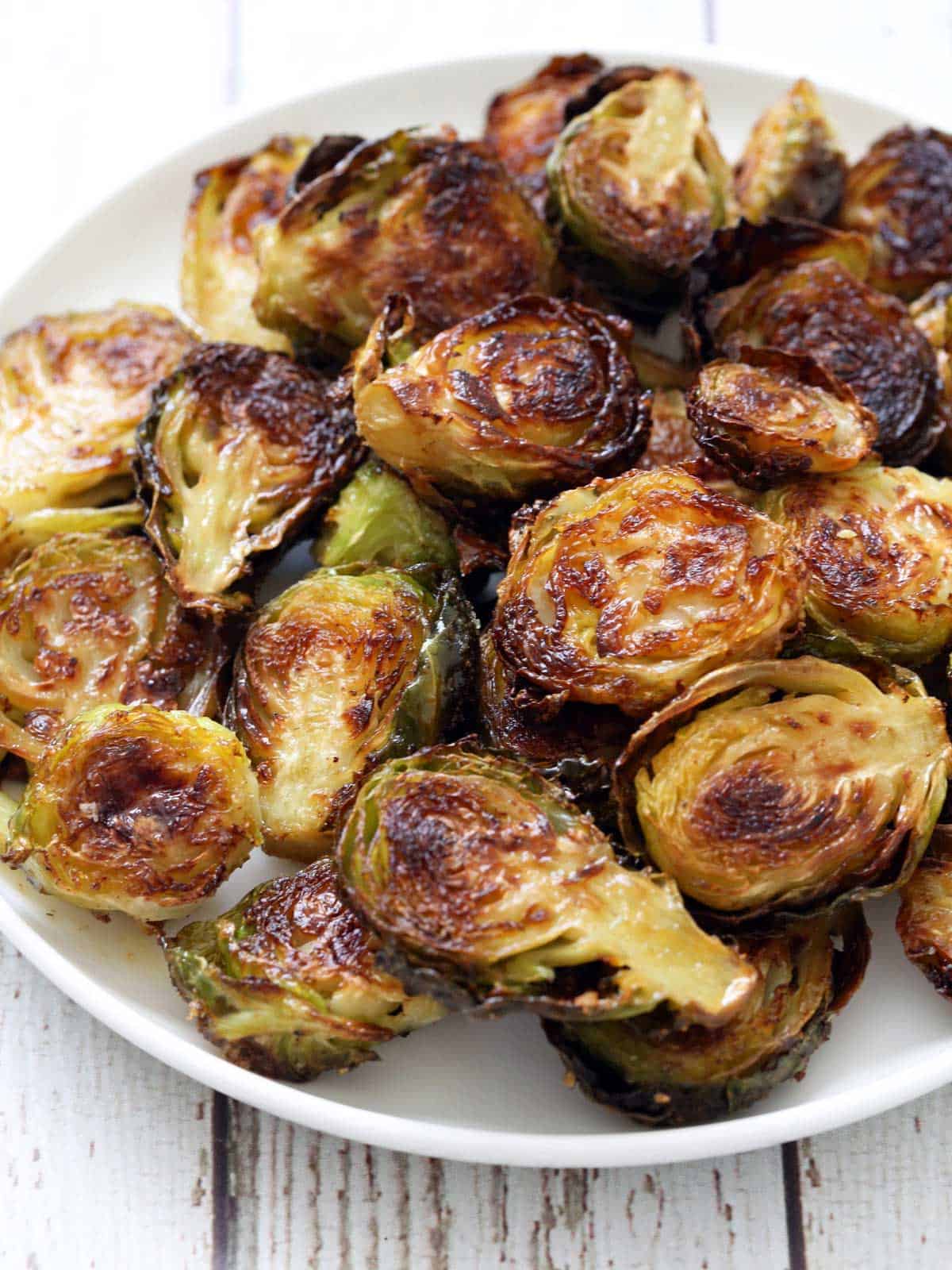 Roasted Brussels sprouts are served on a white plate.