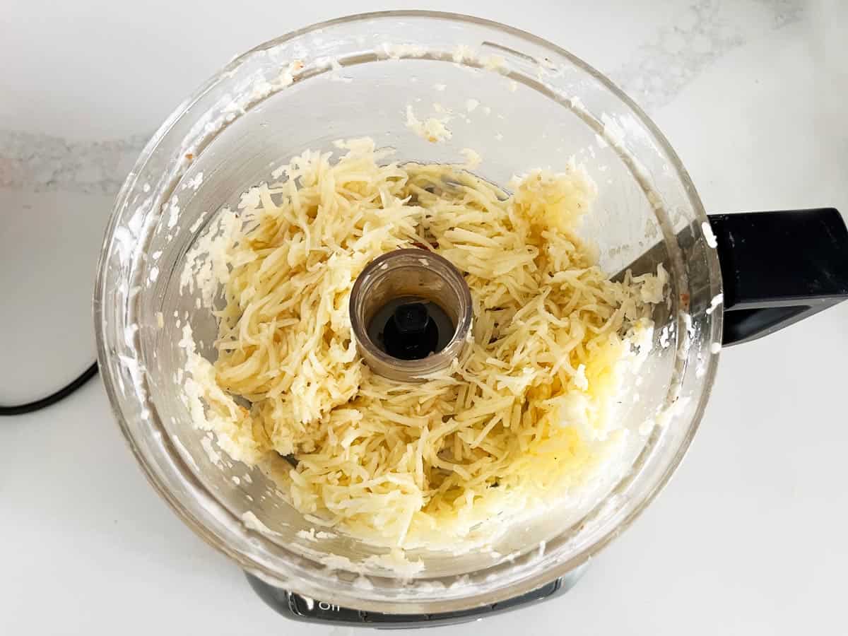 Shredded potatoes in the food processor.