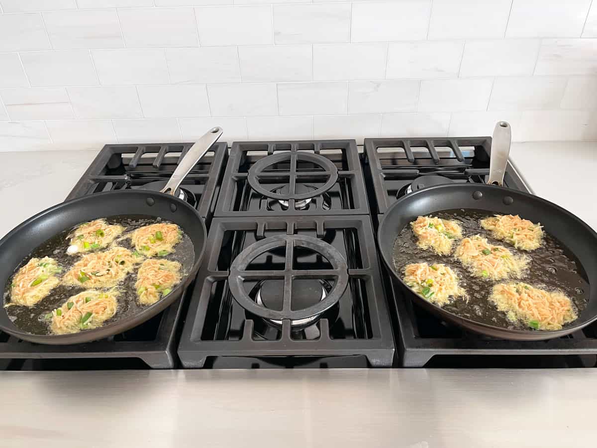 Cooking latkes in two skillets.