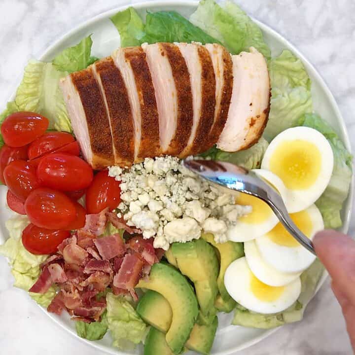 Adding blue cheese to the salad.