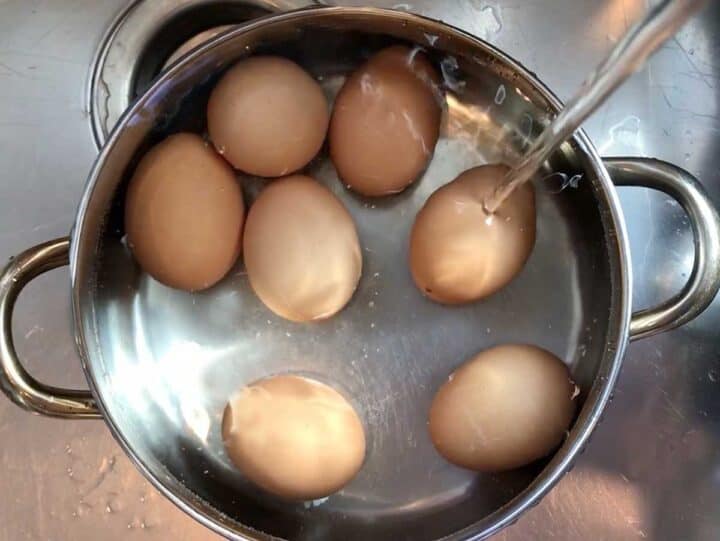 Adding cold water to the pot.