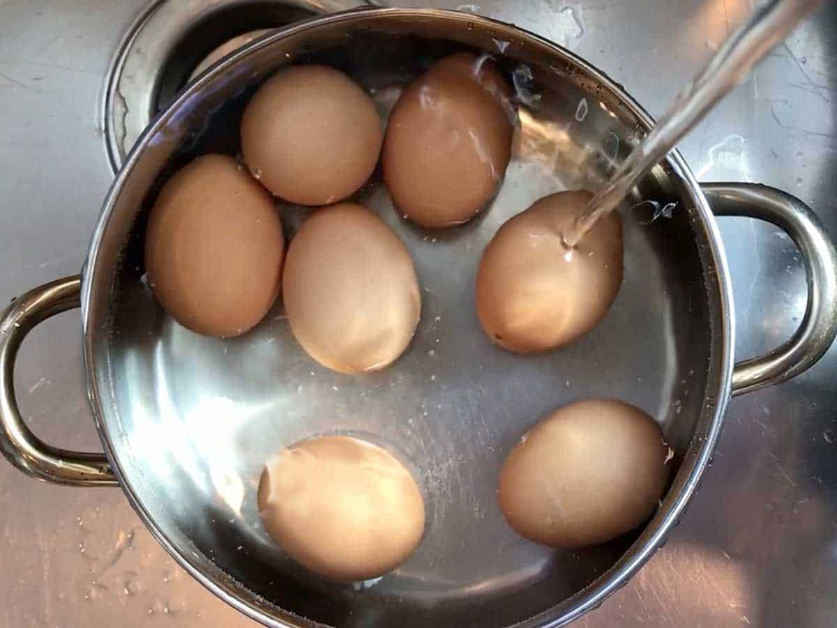 Adding cold water to the pot.