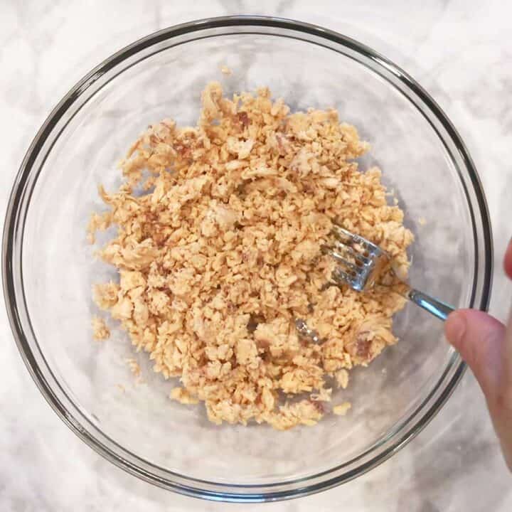 Flaking the salmon in a bowl.