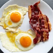 Beef bacon is served with fried eggs.