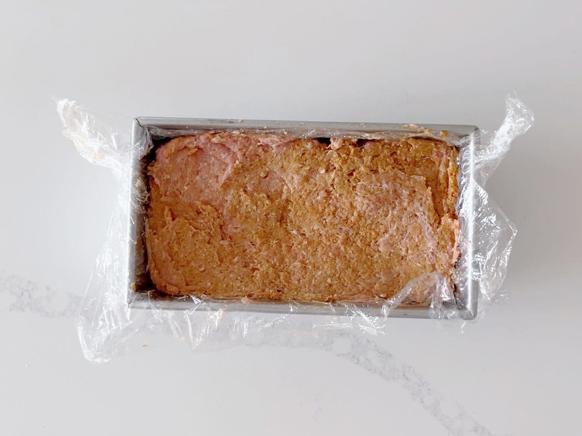 Shaping the meatloaf in a loaf pan.