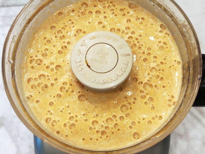 A frothy butternut squash souffle mixture in the food processor.