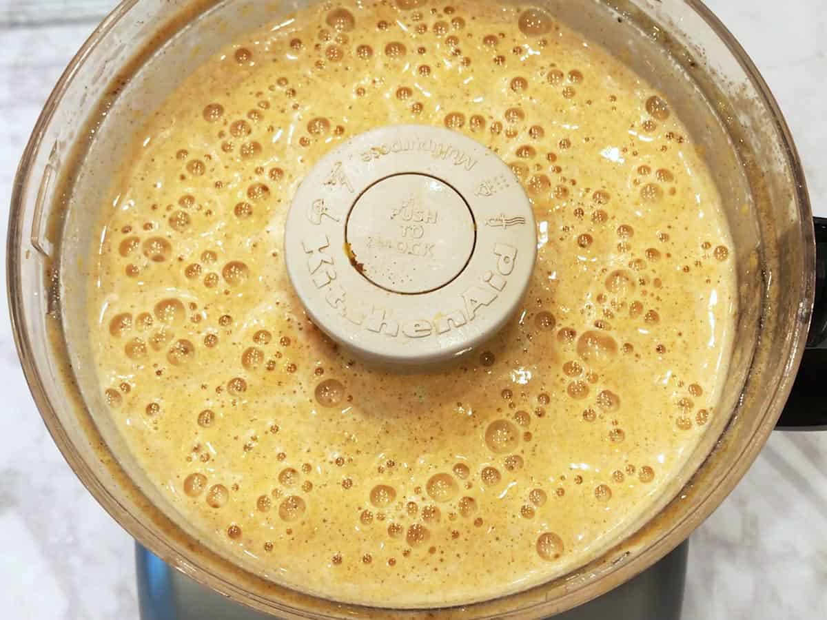 A frothy butternut squash souffle mixture in the food processor.