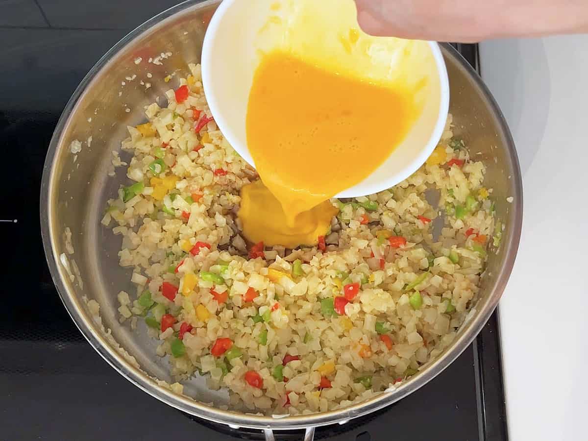Adding the eggs and soy sauce to the skillet.