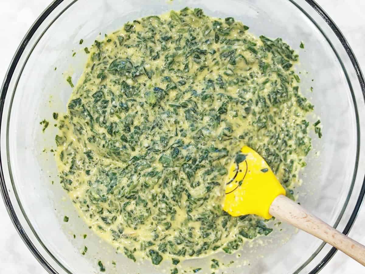 Mixing in spinach and parmesan.