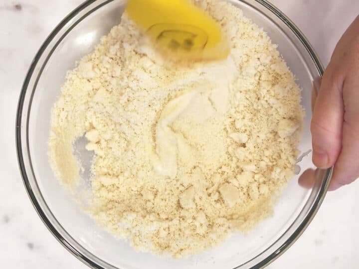 Adding almond flour to the dough.