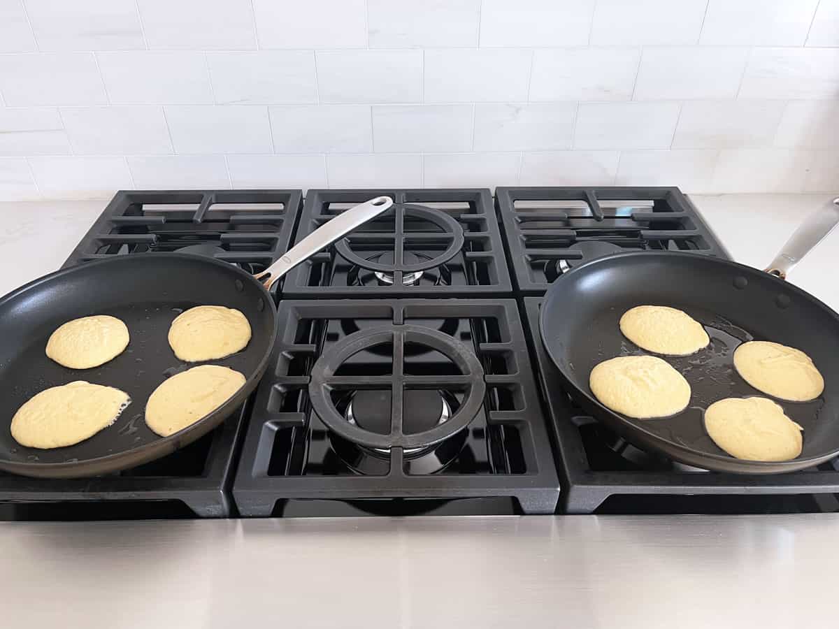 Cooking the pancakes in two skillets simultaneously.