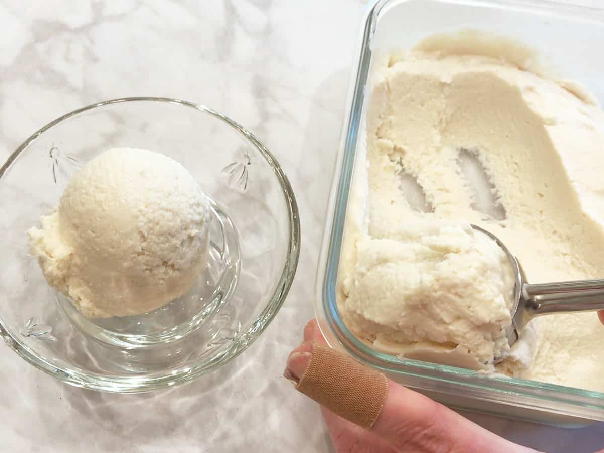 Scooping frozen yogurt into a bowl.