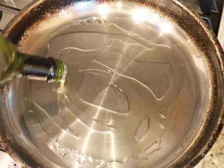 Adding oil to the skillet.
