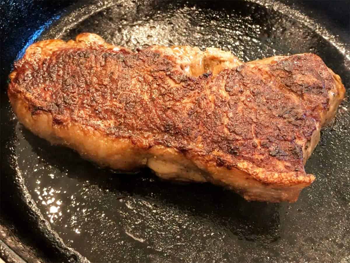 The steak is ready in the skillet.