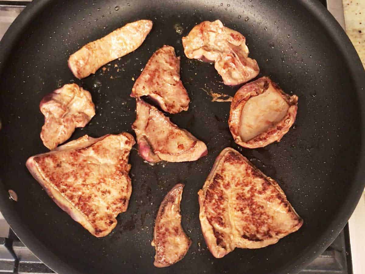 Cooking the livers on the second side.