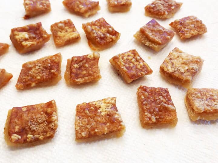 Placing the pork rinds on paper towels to drain.