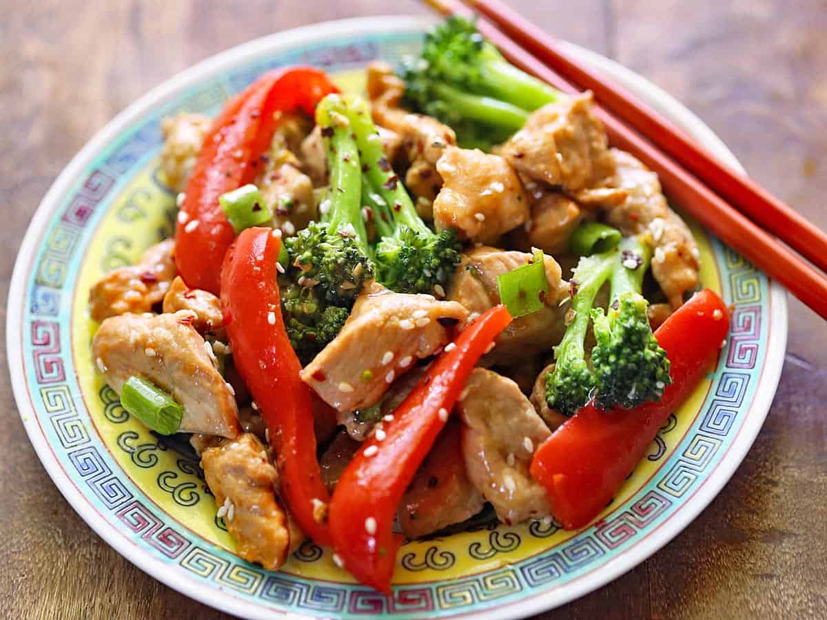 A pork stir fry is served on a Chinese dinner plate.