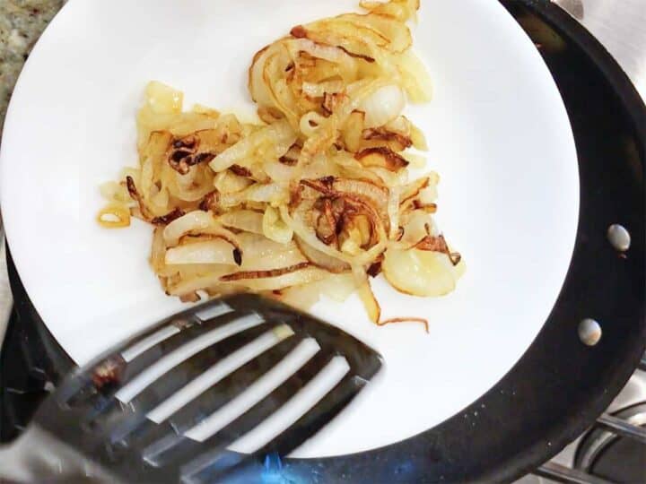 Removing the onions to a plate.