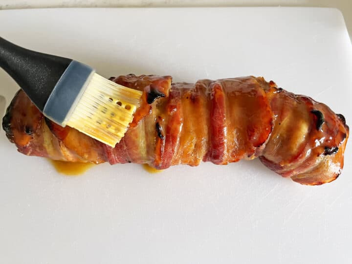 Brushing the fully cooked tenderloin with more sauce.