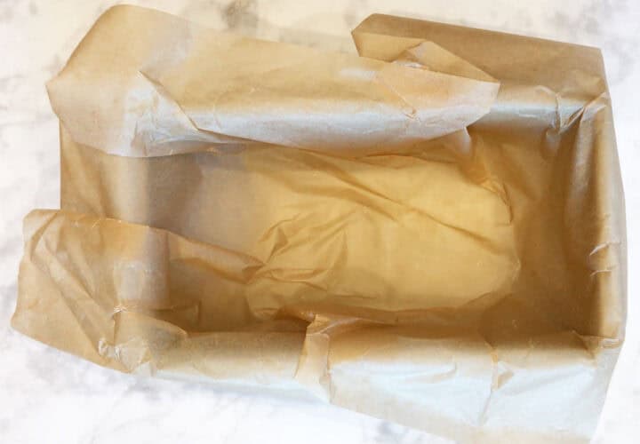A small loaf pan lined with parchment paper.