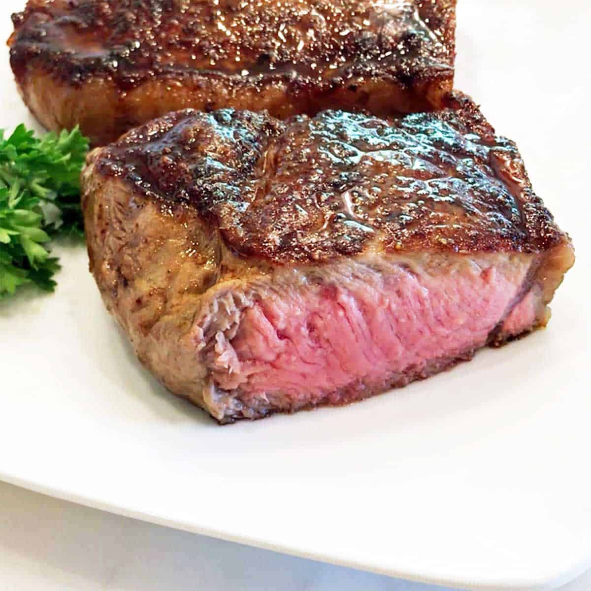 A New York strip steak was cut in half.
