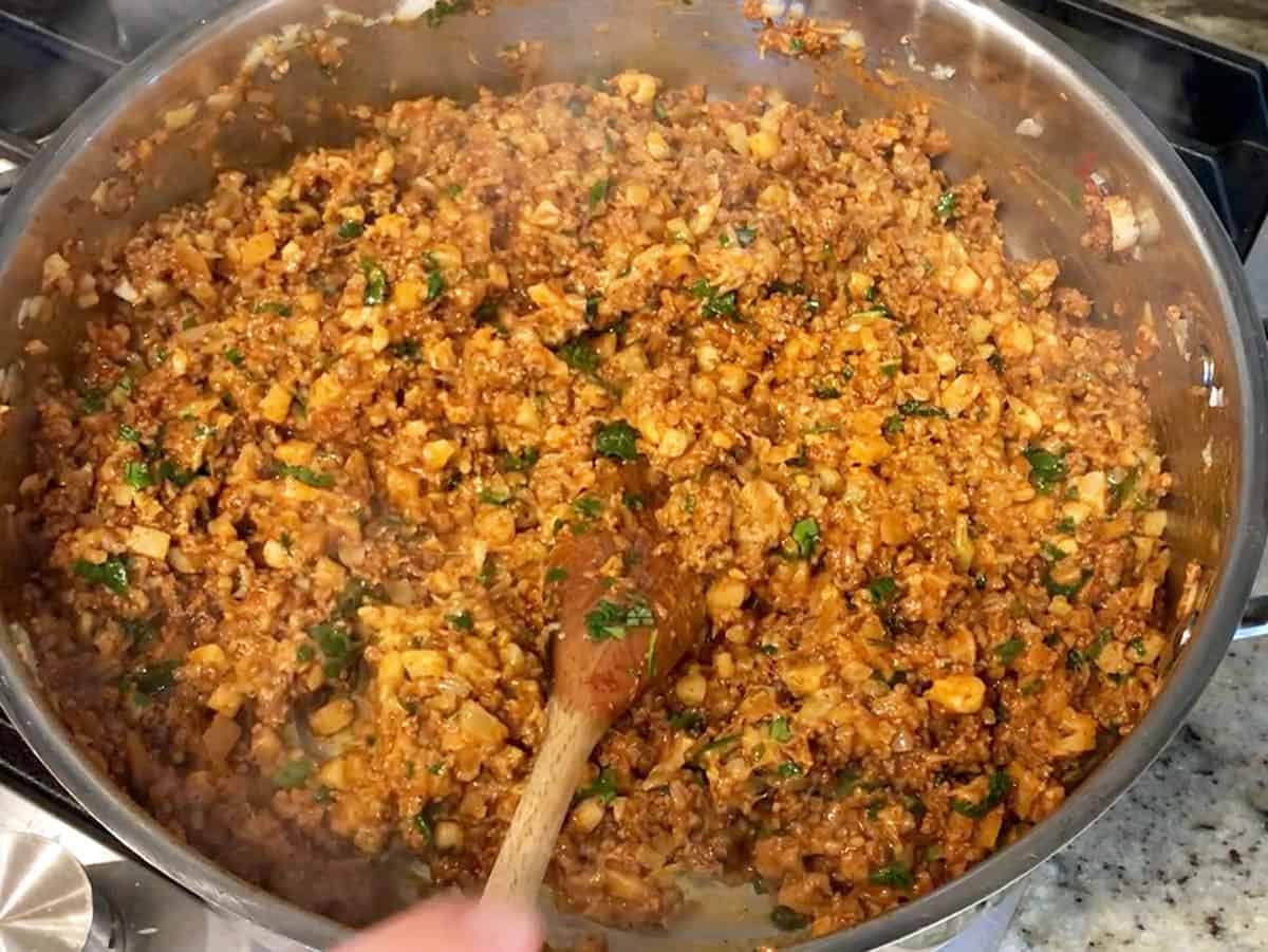 Adding spices, cilantro, and cheese.