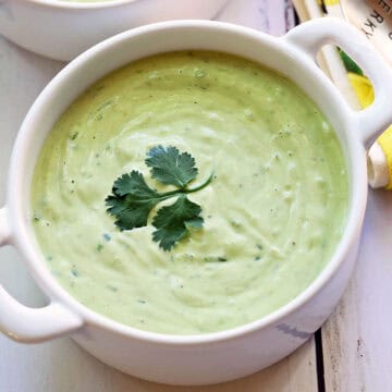Avocado soup is served in a white bowl.
