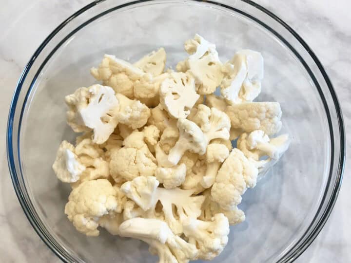 Raw cauliflower florets in a bowl.