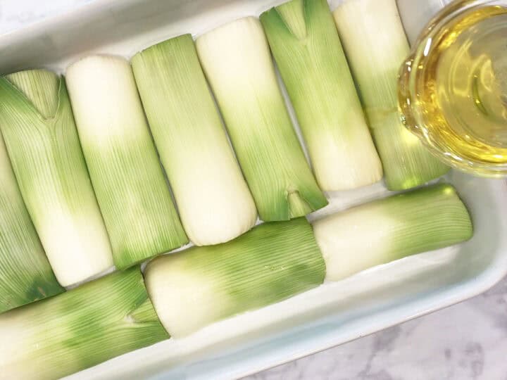 Drizzling the leeks with olive oil.