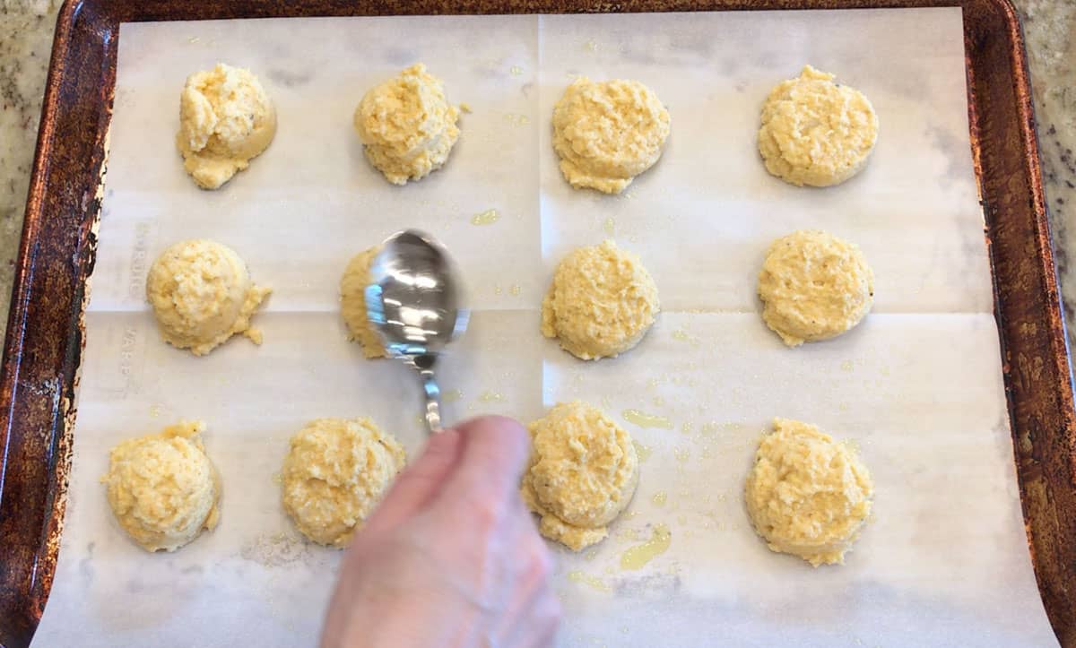 Placing the mounds on the pan and flattening them.