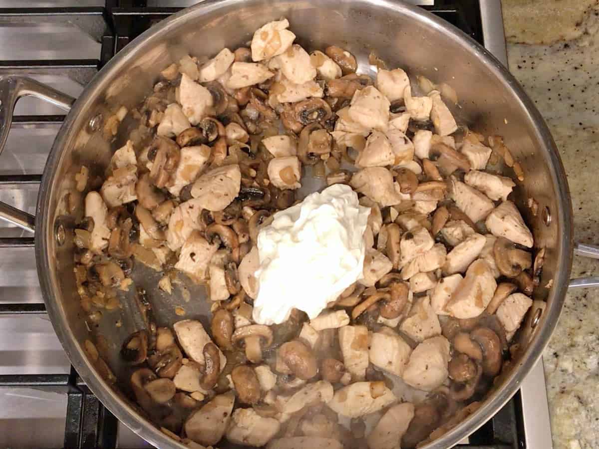 Adding the sour cream to the skillet.